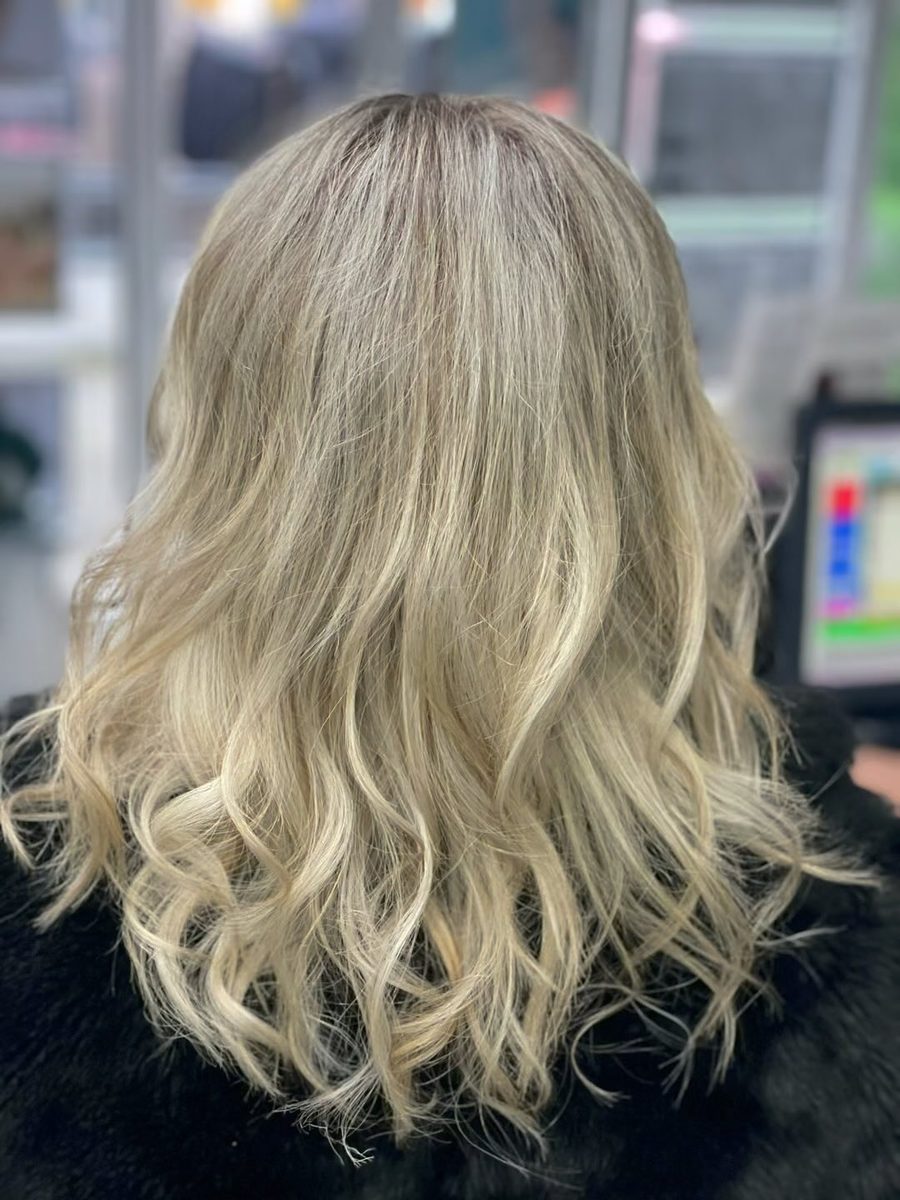 Soft blonde balayage with loose waves, styled at Lux Studio