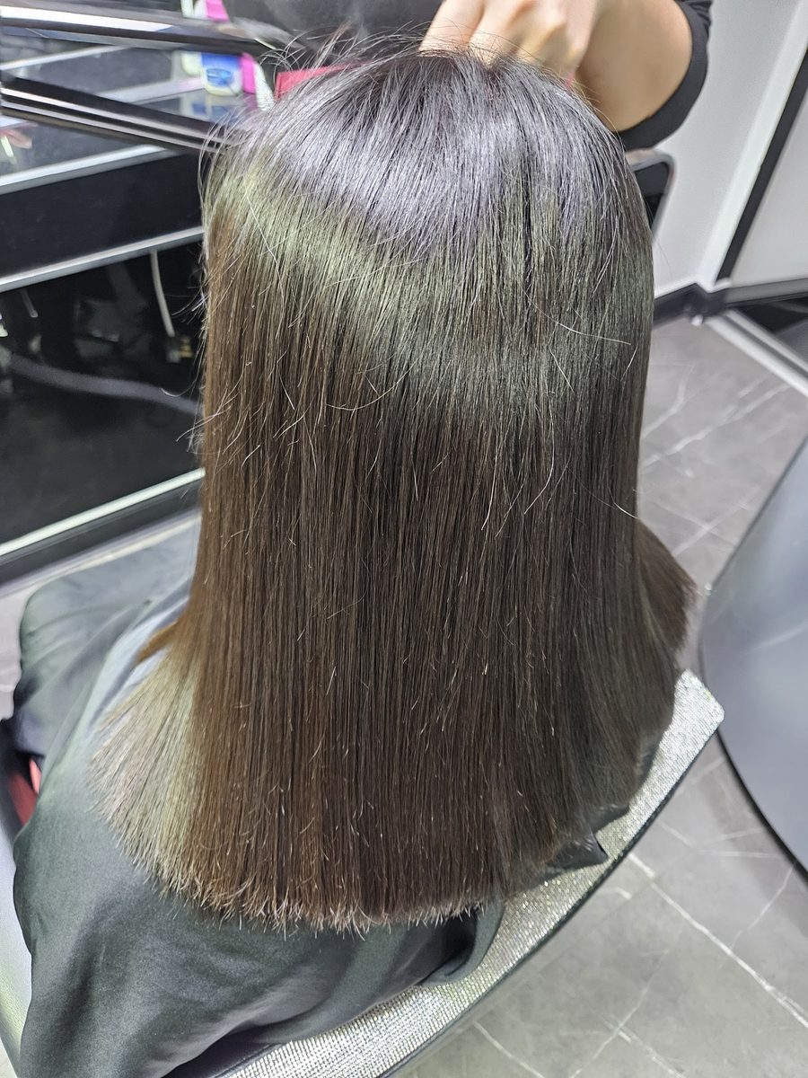Sleek dark hair after a keratin smoothing treatment at Lux Studio